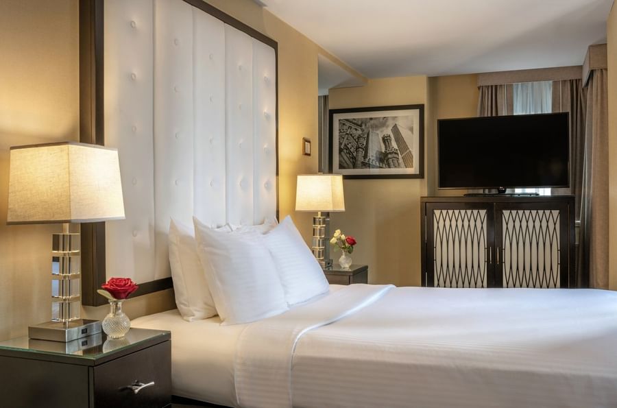 TV on the cupboard by the bed with side tables in Superior Suite at Warwick Allerton Chicago