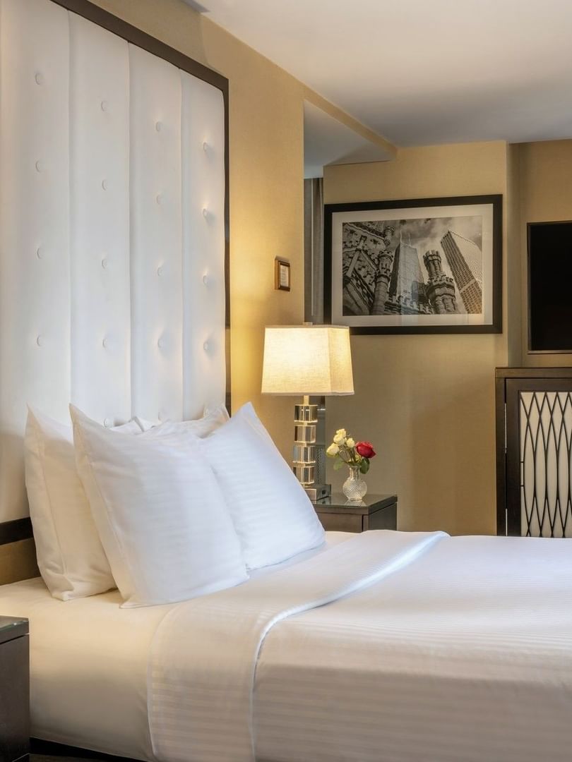 TV on the cupboard by the bed with side tables in the Executive King at Warwick Allerton Chicago