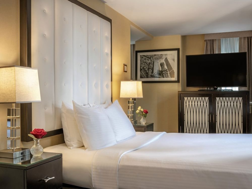 TV on the cupboard by the bed with side tables in the Executive King at Warwick Allerton Chicago