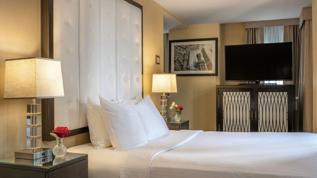 TV on the cupboard by the bed with side tables in the Executive King at Warwick Allerton Chicago