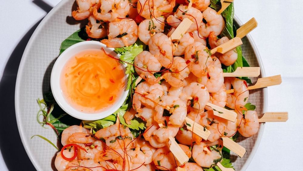 Platter of grilled shrimp skewers served with dipping sauce in Freshwater Ballroom at Novotel Sydney Olympic Park
