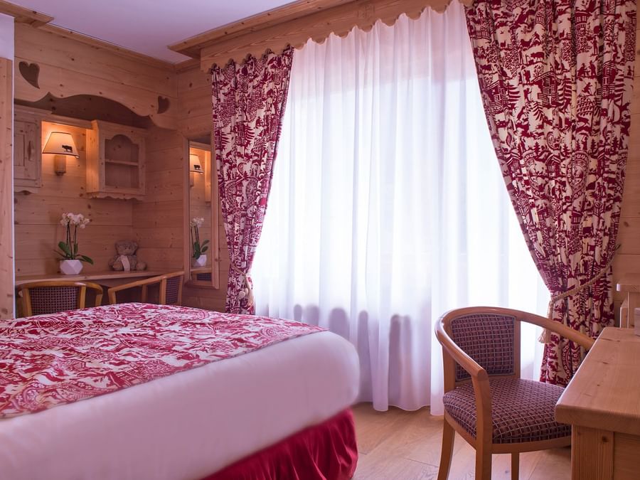 Interior of a double bedroom with writing desk at Chalet hotel.