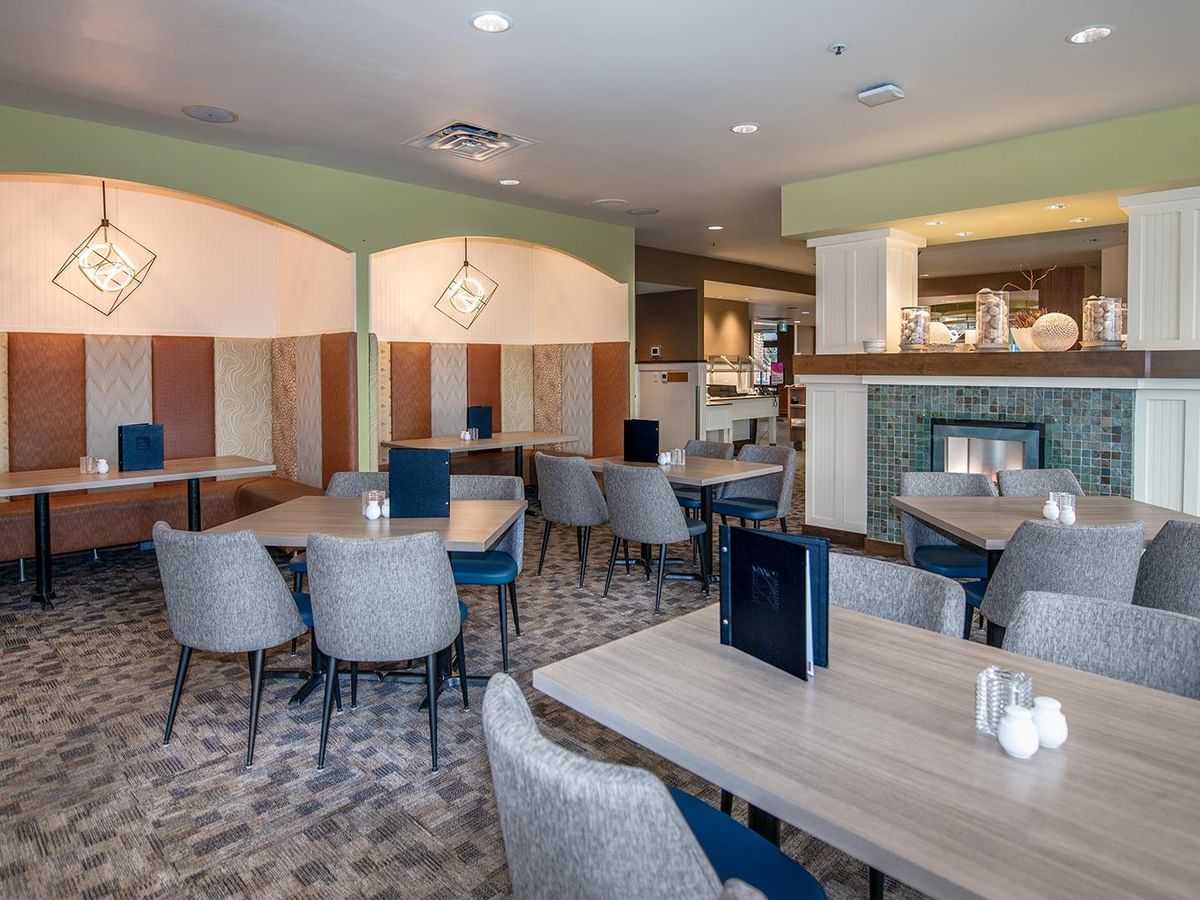 Dining area with tables and chairs at Minnoz Restaurant + Lounge in Nanaimo at Coast Bastion Hotel.
