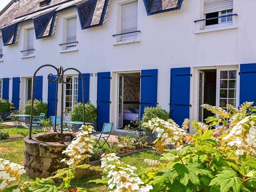 Façade avec jardin et mobilier d'extérieur à Hôtel La Marébaudière.