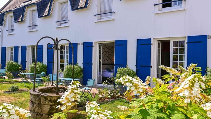 Façade avec jardin et mobilier d'extérieur à Hôtel La Marébaudière.