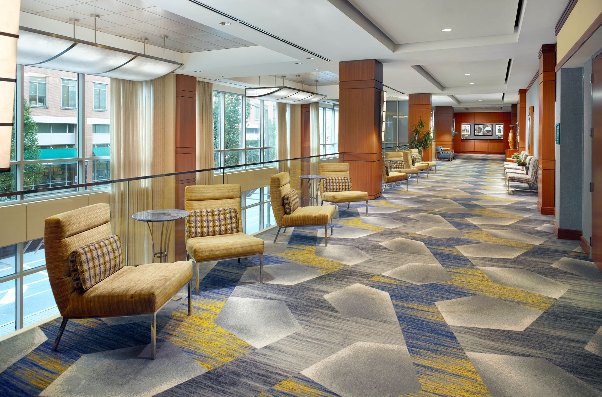 A spacious lobby with modern furniture and a patterned carpet.