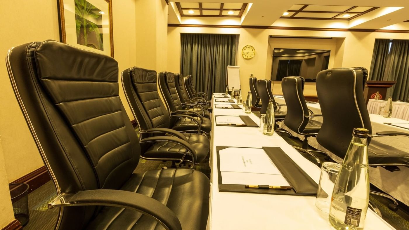 Black chairs and white table setup in Ngamba Hall at Lake Victoria Serena Golf Resort & Spa in Kampala.