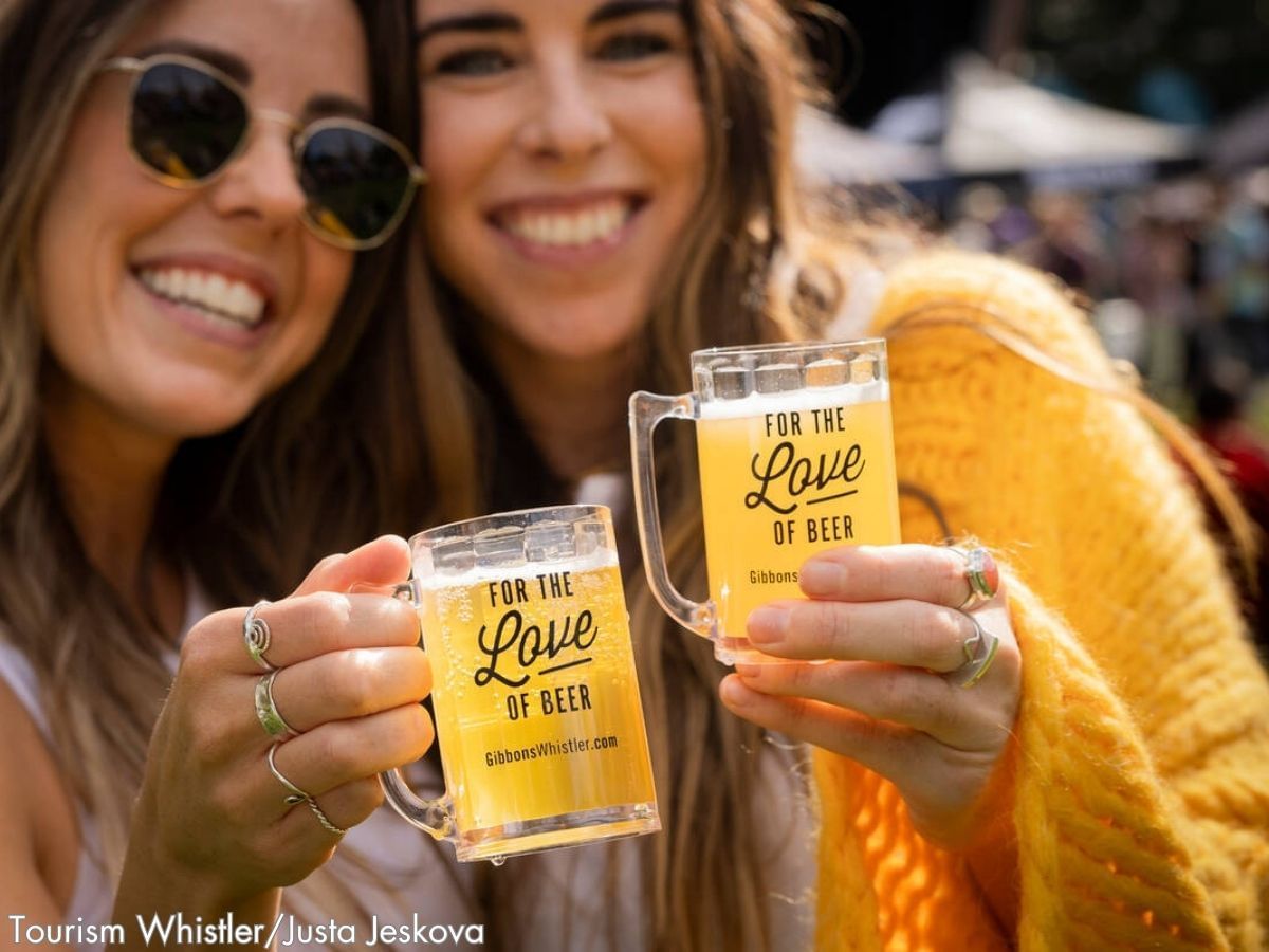 Happy ladies toasting beer glasses in The Whistler Village Beer Festival near Blackcomb Springs Suites
