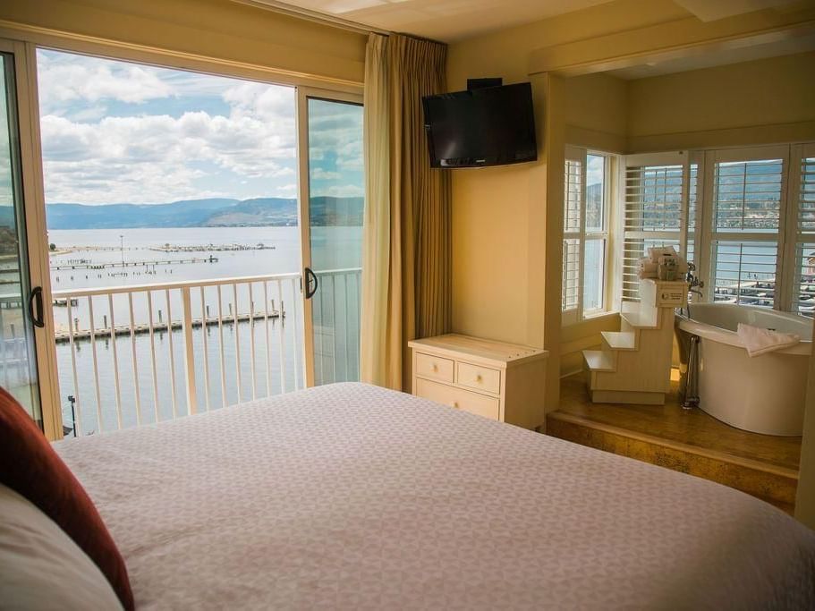 Bed & bathtub in a room overlooking the lake at Hotel Eldorado