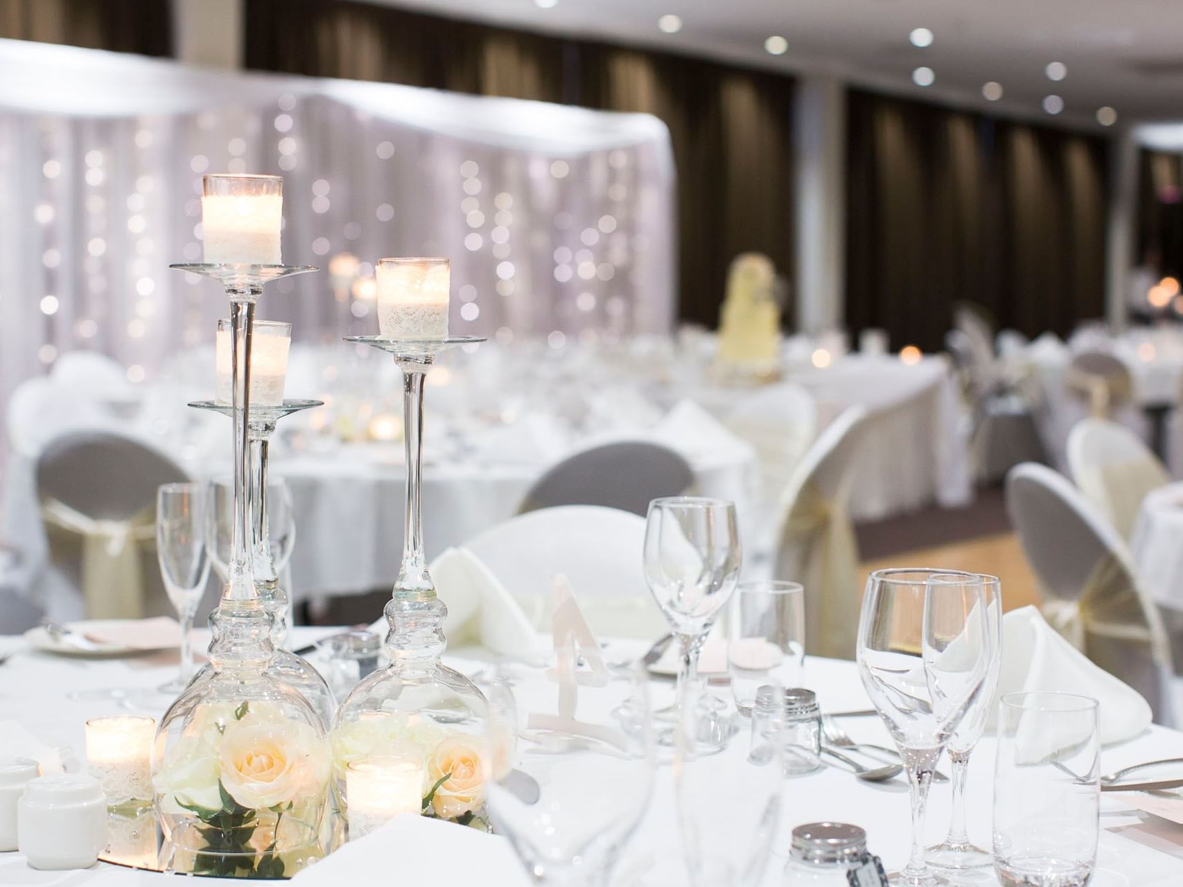 Candles & glassware set-up on a table with white theme decor at Grand Chancellor Townsville