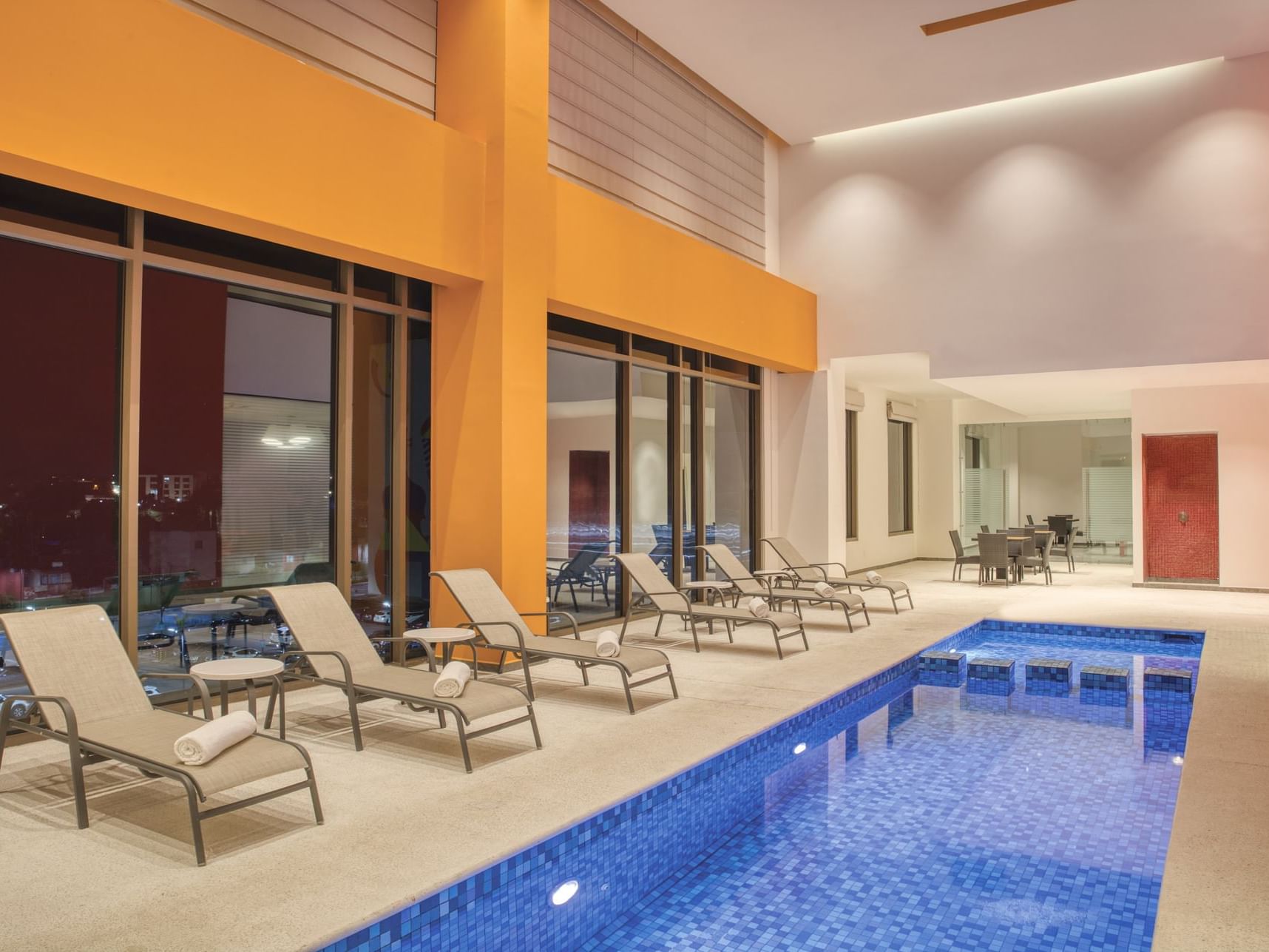 Indoor swimming pool area with sunbeds at Fiesta Inn