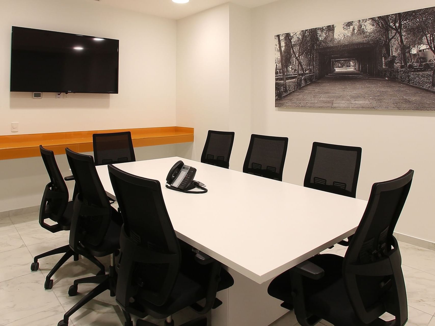 Conference table, wall TV & a wall painting at One Hotels