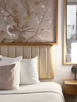 Close-up of bed with pillows by side table in Accessible King Room at Warwick Allerton Chicago