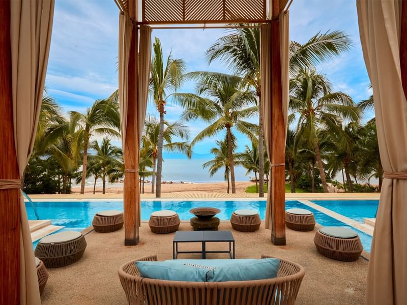 Poolside cabana with a view of the beach and palm trees at Fiesta Americana