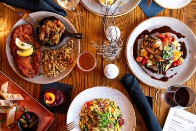 Diverse gourmet dishes on a wooden table in The Lodge at Schroon Lake