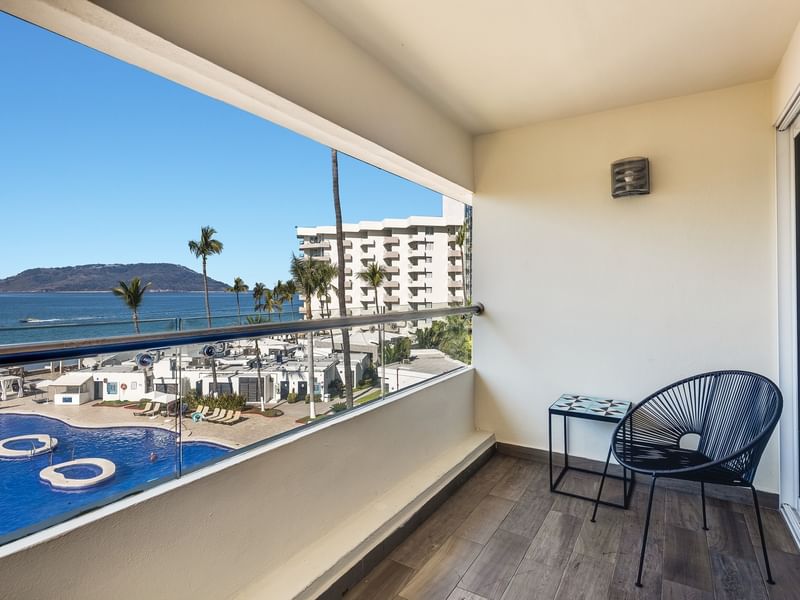 Junior Suite Vista Parcial Al Mar with a stylish black chair and a view of the pool and ocean at Sunvivia Mazatlán