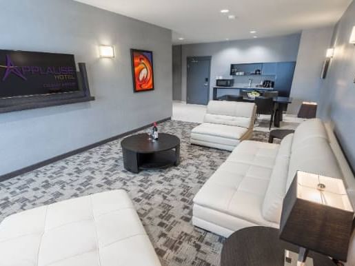 Living area with sofas & kitchenette in Executive One Bed Suite at Applause Hotel Calgary