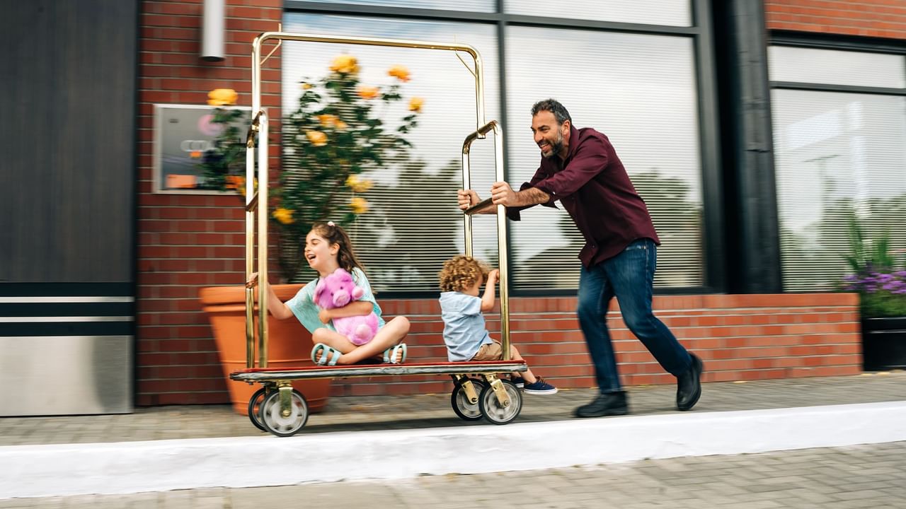 kids riding on a hotel luggage cart