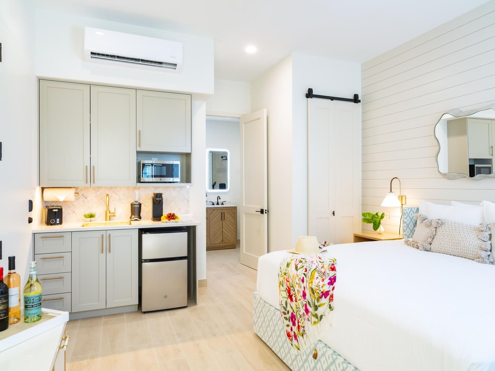 Bright, modern Standard Room with kitchenette, plush bed, stylish decor, and bathroom view at Windsong Resort On The Reef