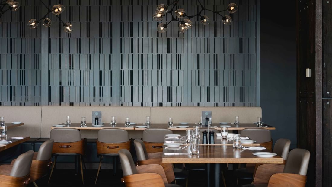 Karinyas Restaurant interior with wooden tables, chairs, and stylish pendant lights at Mercure Kooindah Waters
