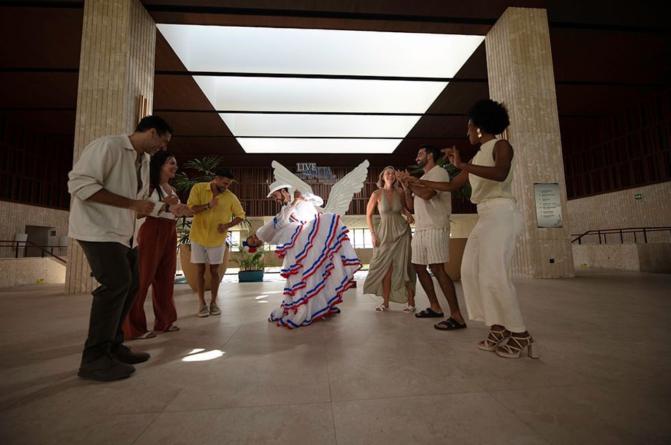 People in casual attire dancing in a lobby at Live Aqua Resorts and Residence Club