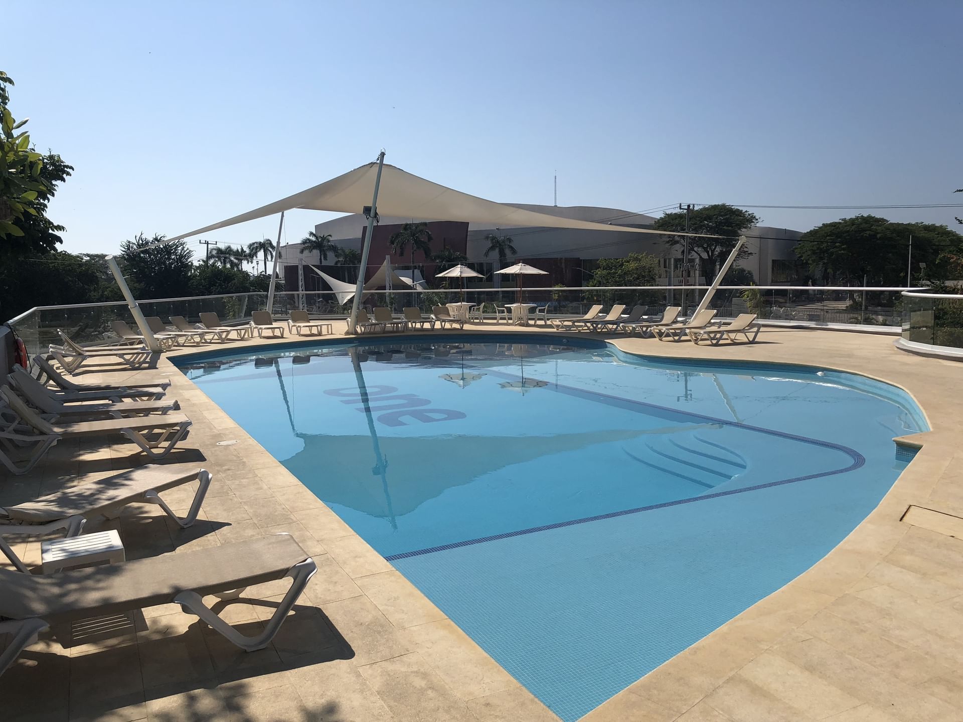 Terraza piscina con tumbonas a su alrededor en One Hotels