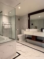 Modern bathroom with walk-in shower and dual vanity at Warwick Fiji Resort and Spa in Korolevu.