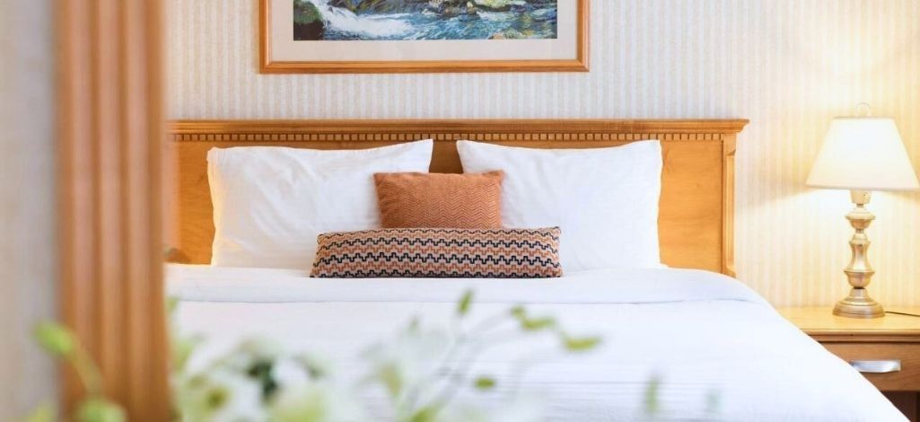 Guest room interior with neatly made bed warm lighting and comfortable furnishings at Listel Whistler, a Coast Hotel