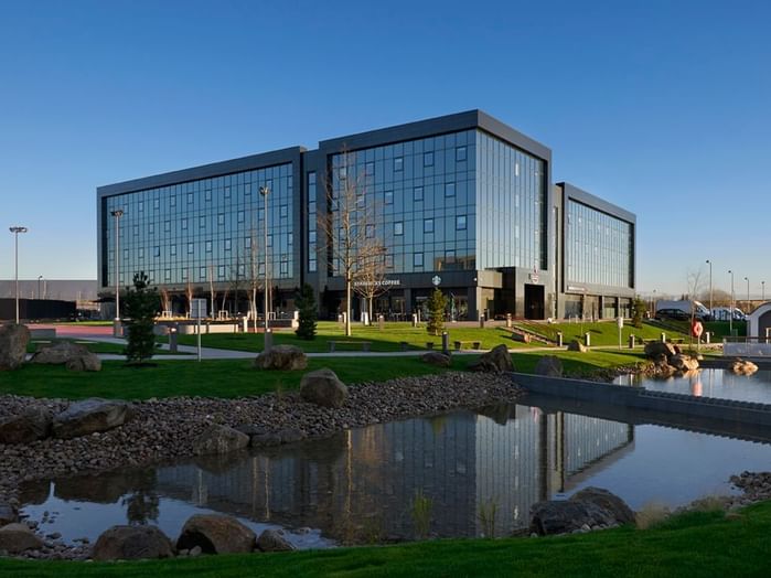 An exterior view of the hotel & the pond at Village Hotels