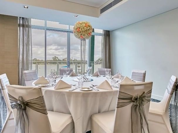 Elegant wedding table at The Sebel Mandurah, featuring formal place settings and a floral centerpiece with a lake view