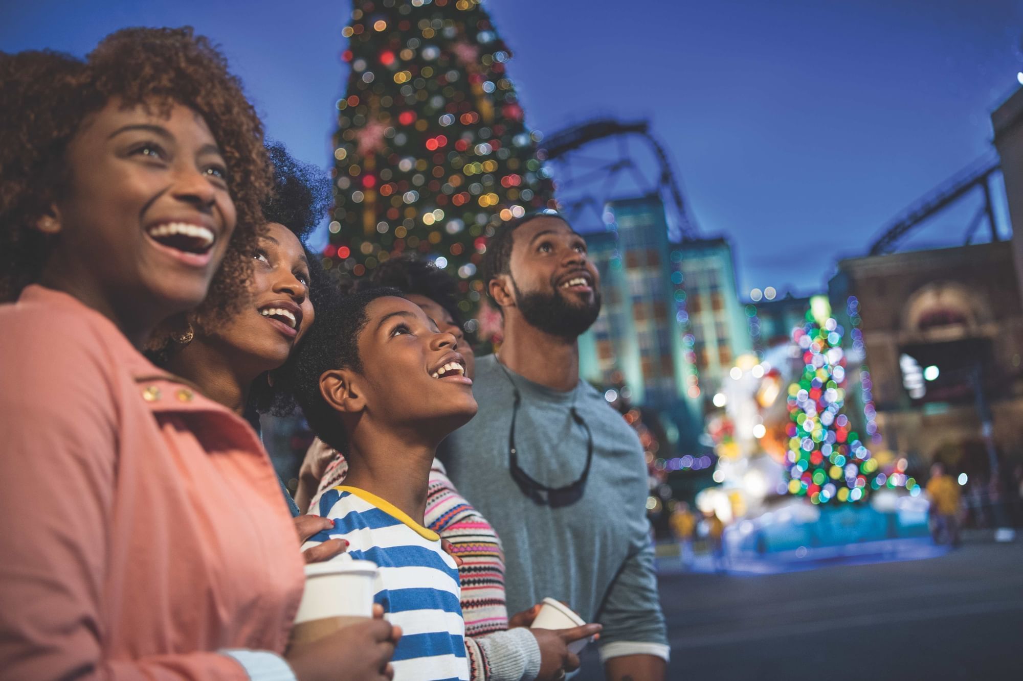 A family looks around the streets of Universal at night, lit up and decorated for the holidays. 