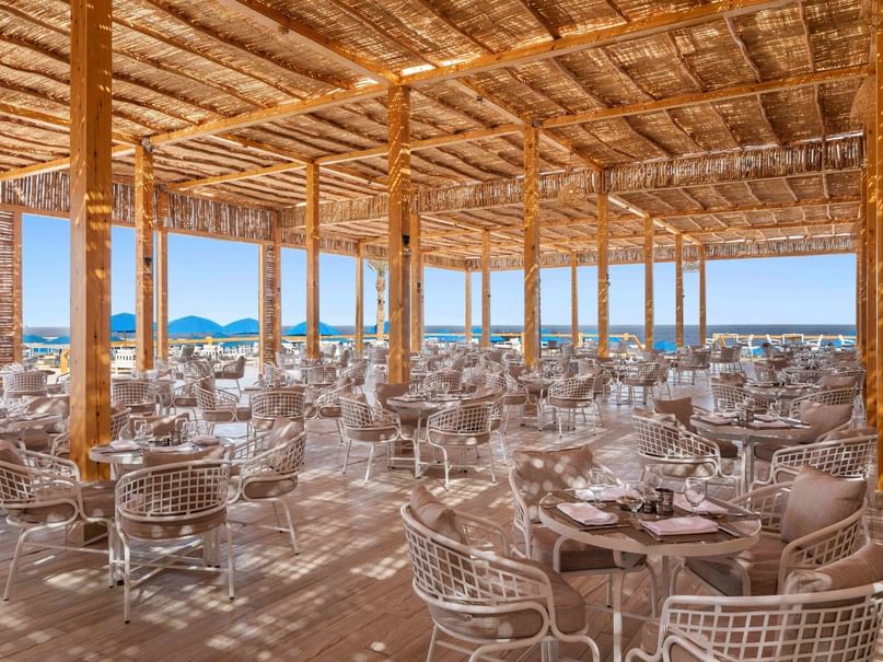 Spacious Beach Club dining area with many tables and chairs under an open-air canopy at Pickalbatros Sea World Resort.