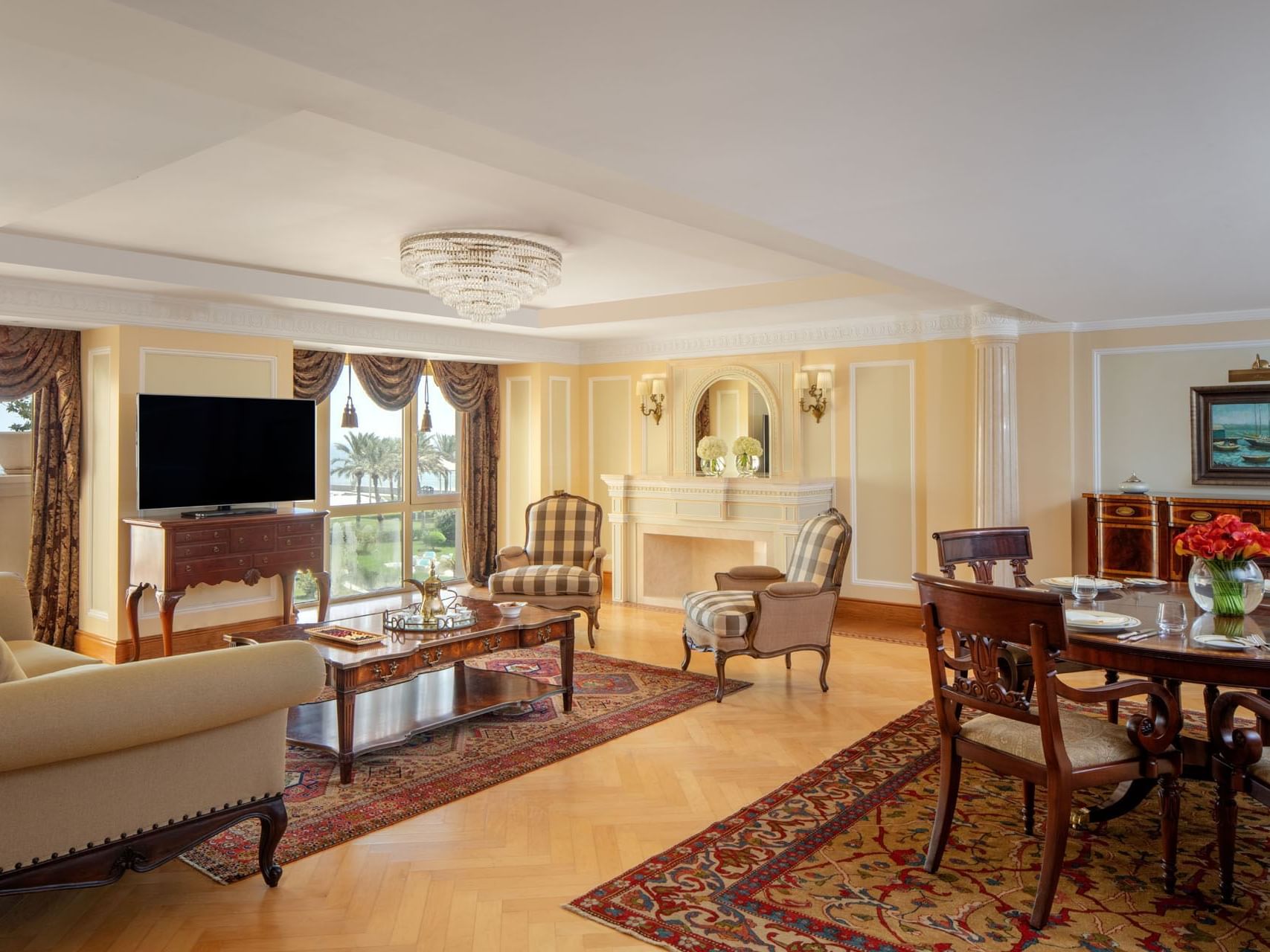 Living area with a TV & sofas in Qaruh Suite, The Regency Hotel