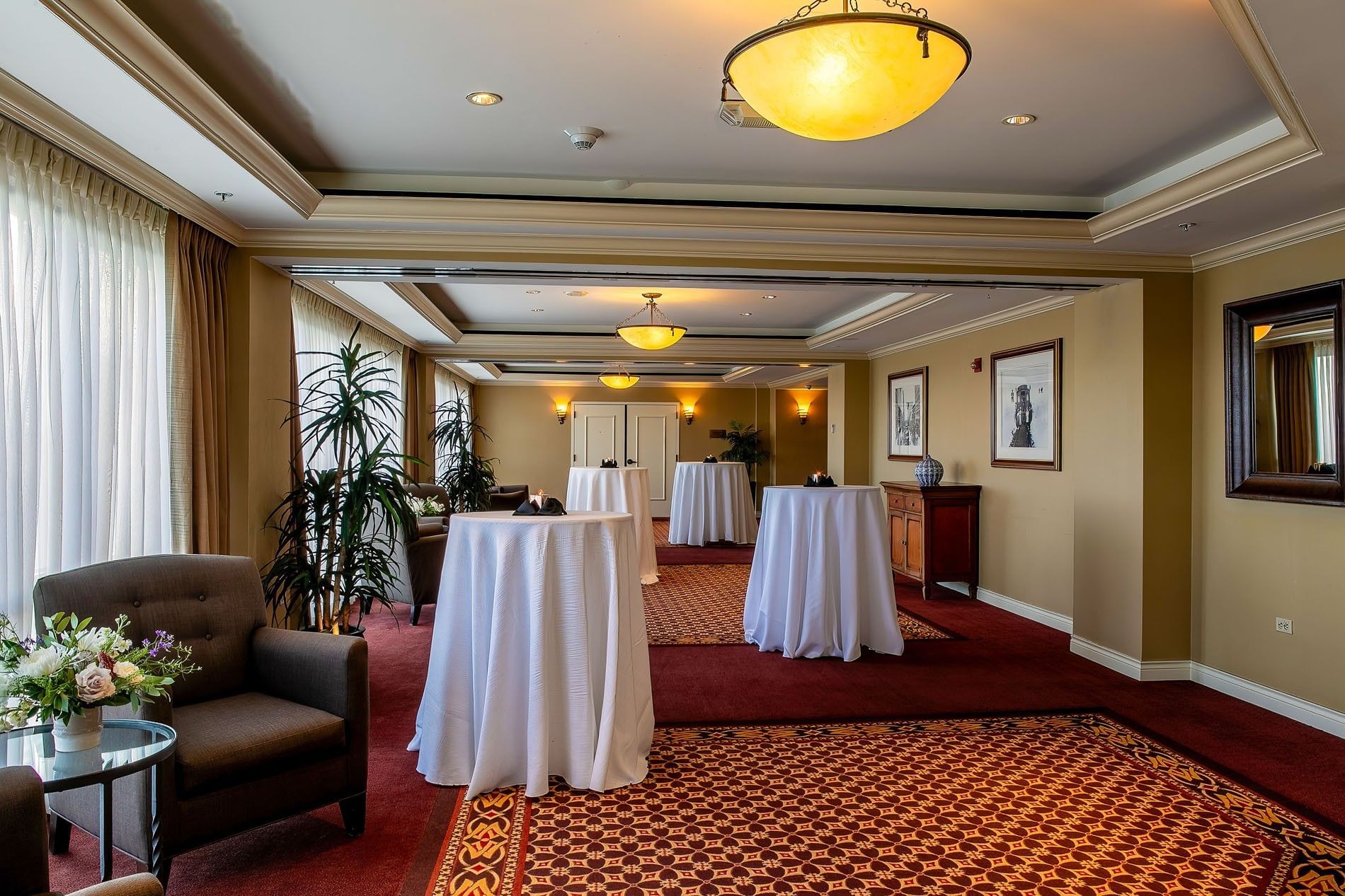 Cocktail tables with white cloths by an armchair under dome in Millennium at Warwick Denver