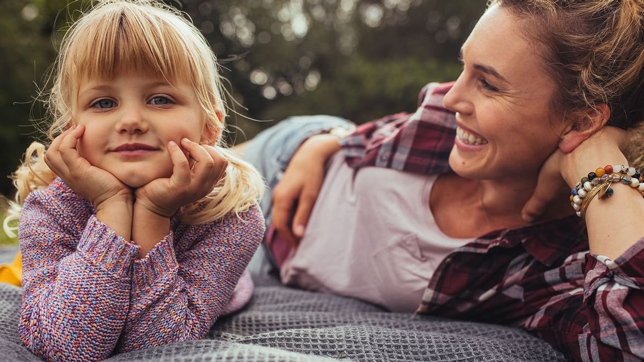 Child and Mom lying on a blanket on grass