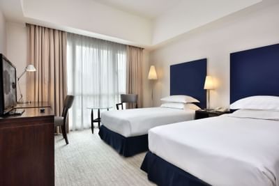 Twin beds in Deluxe bedroom at Hotel Capitol Kuala Lumpur