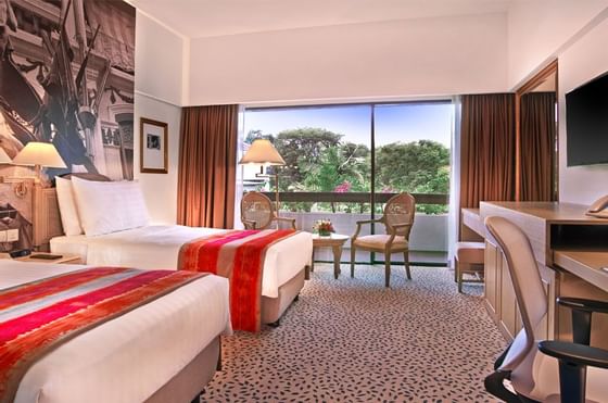 Beds with working area in Deluxe Poolside Room at Goodwood Park