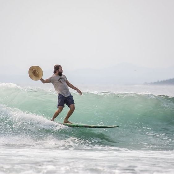 A man surfing against the tide waves near Cala de Mar Resort