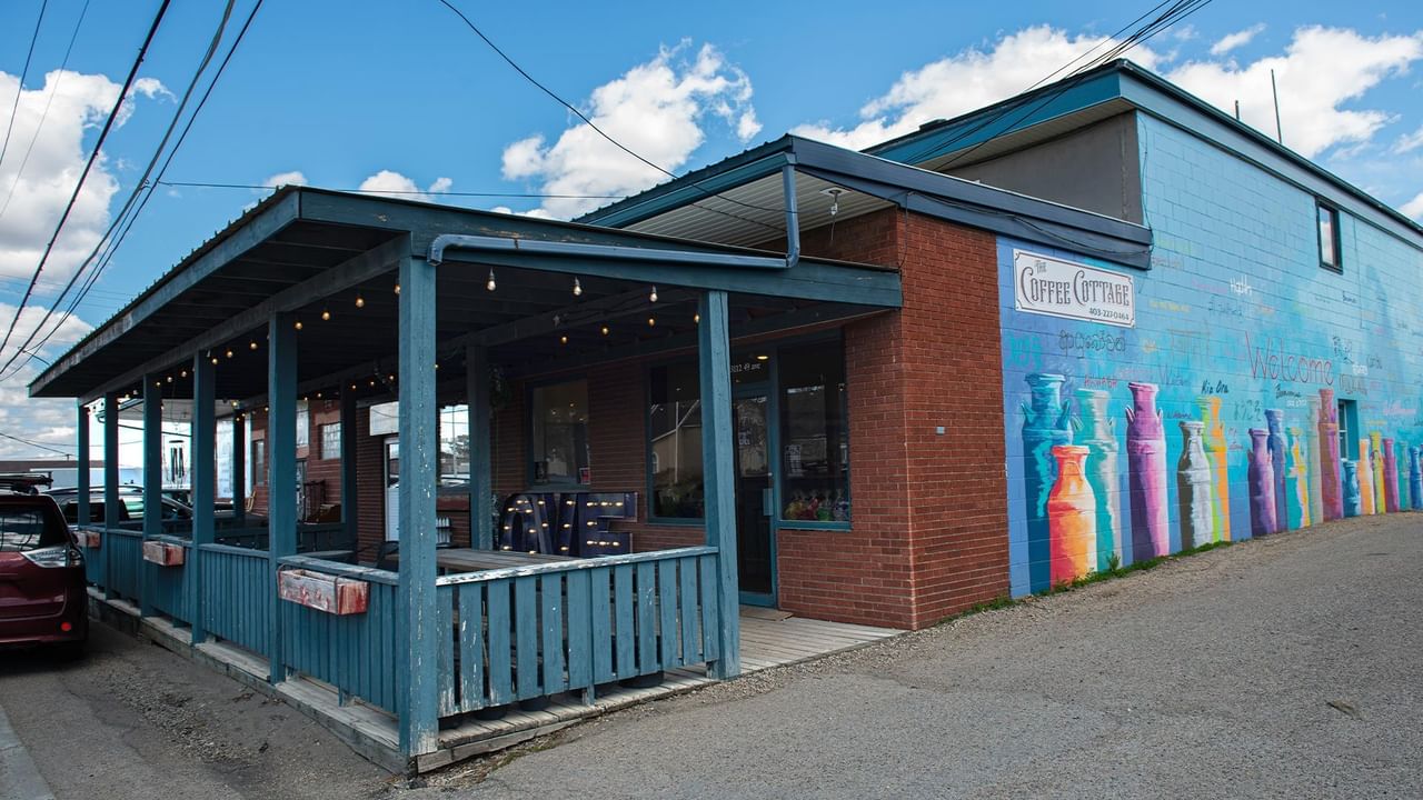 Blue building with colorful murals and outdoor seating.