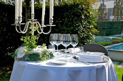 Outdoor dining table set up with glassware & candle holders in V Piano Attico Gourmet Restaurant at Grand Visconti Palace