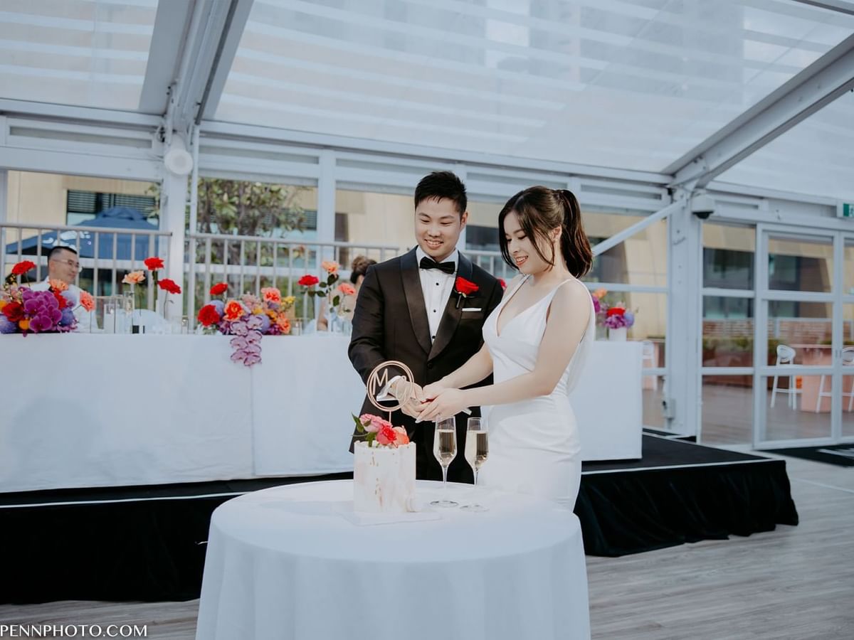 Mai and Godwin cutting a wedding cake at Crown Towers Perth