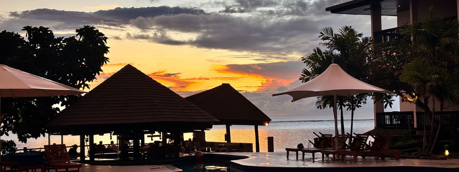 Sunset over the ocean with pool and Grill Pool Bar at Warwick Fiji Resort and Spa in Korolevu