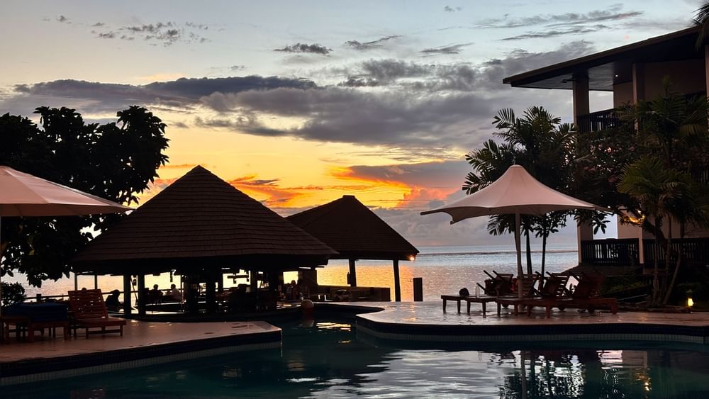 Sunset over the ocean with pool and Grill Pool Bar at Warwick Fiji Resort and Spa in Korolevu.