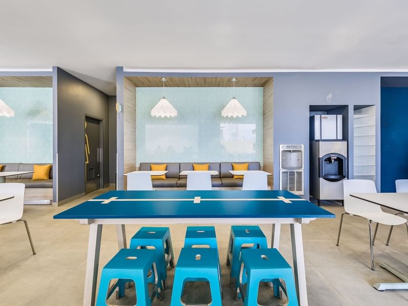 Modern office break room with dining tables at One Hotels