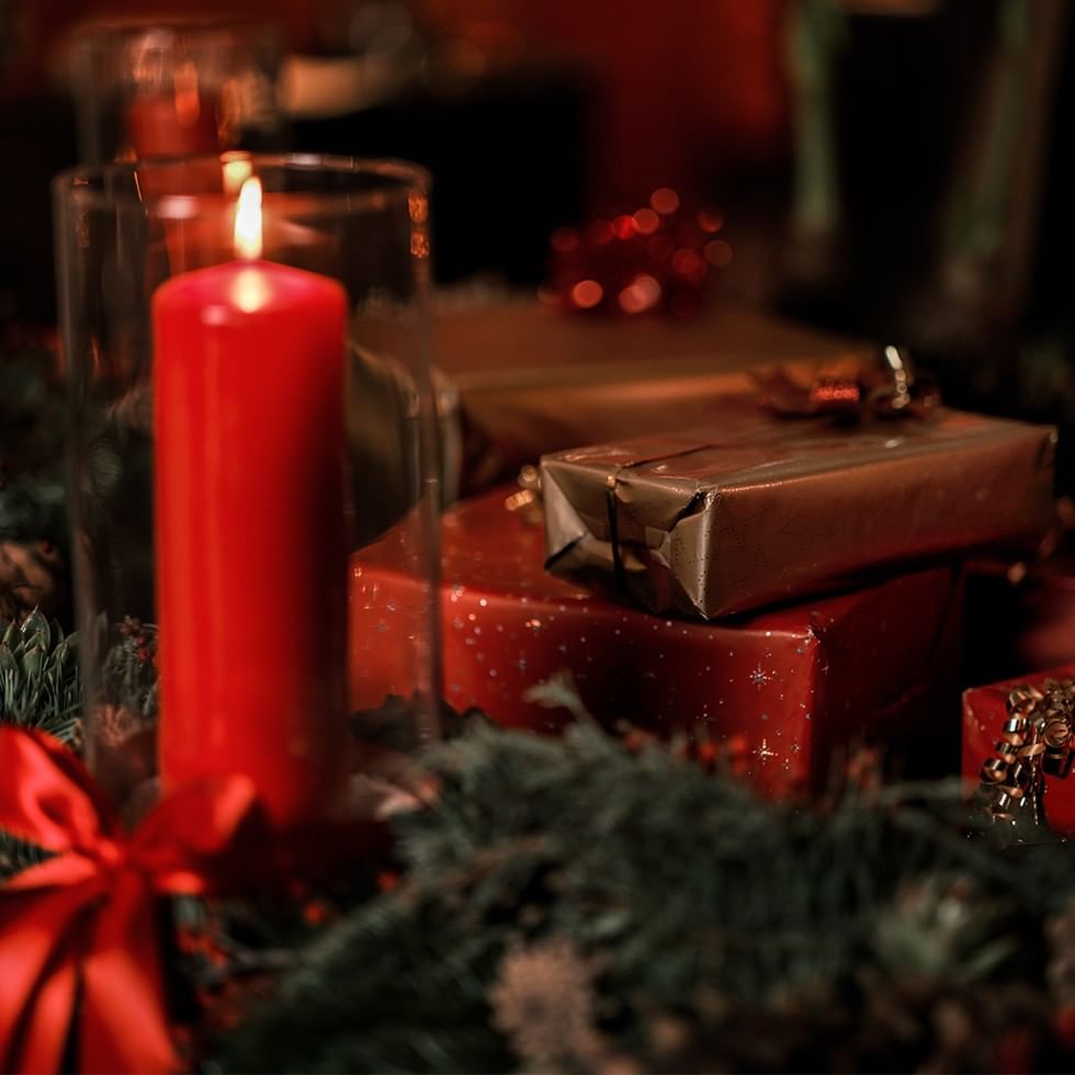 Rote Kerze und Geschenke unter dem Christbaum für Montafoner Bergweihnacht.