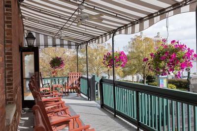 Outdoor seating area with armchairs on a balcony at River Street Inn