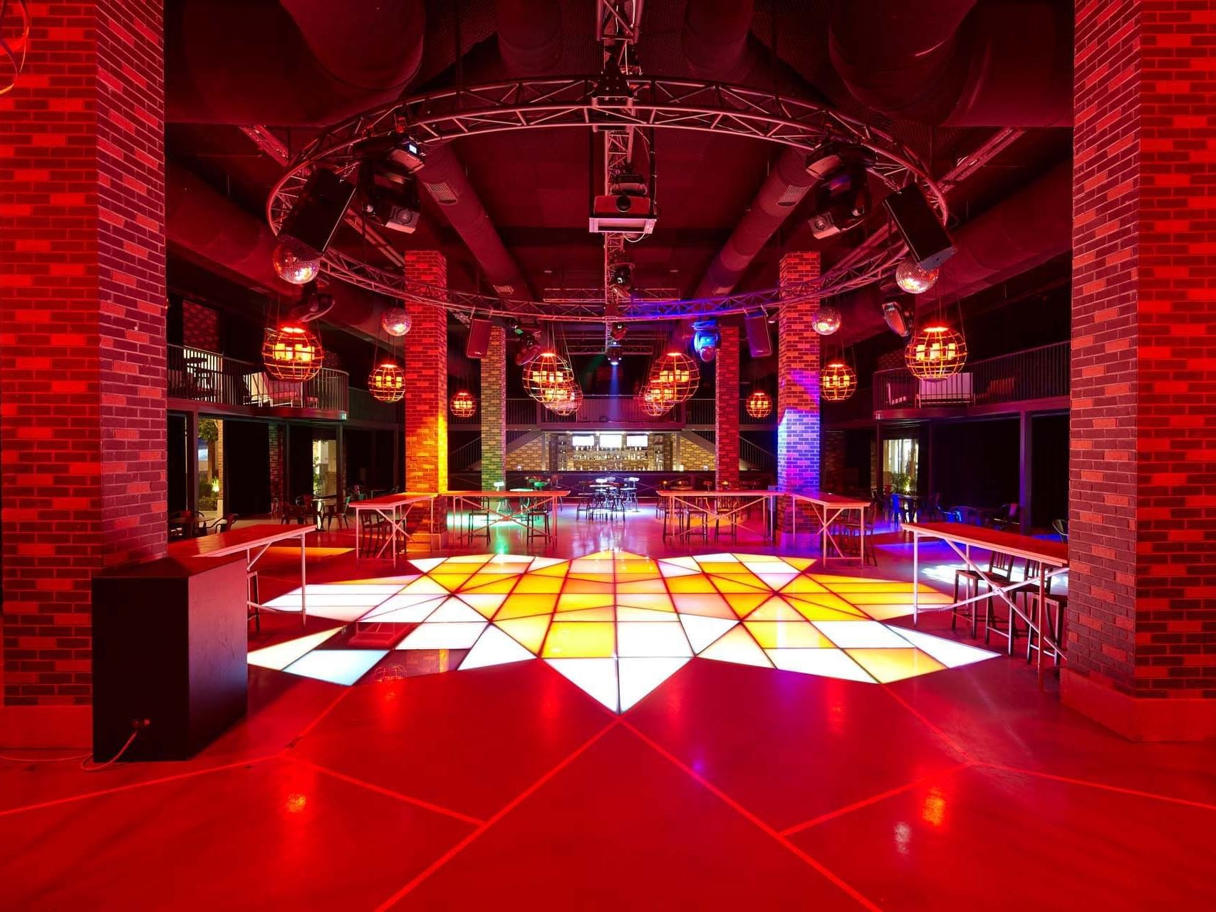 Nightclub with dance floor, red lighting, and DJ booth at Titanic Deluxe Golf Belek
