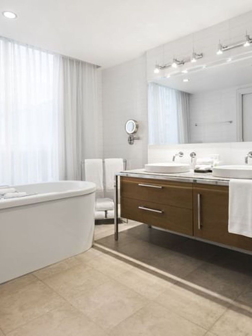 Bathroom with bathtub and double sink at Warwick Le Crystal – Montreal in Montreal.