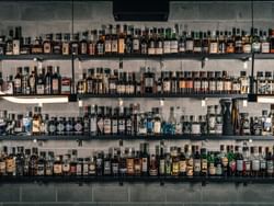 Stolen Goods Cocktail Bar featuring numerous bottles of alcohol neatly arranged on shelves, near ReStays Ottawa