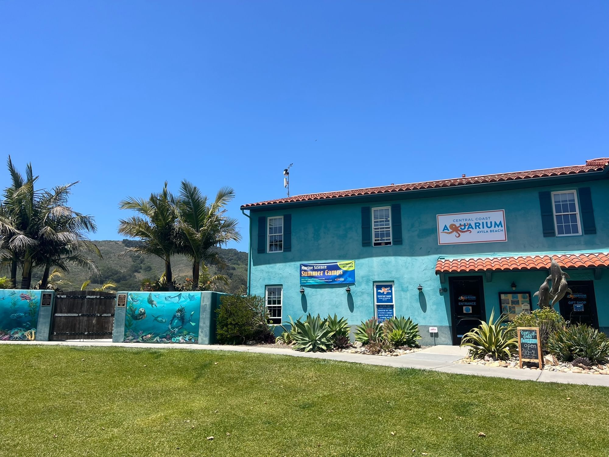 Central Coast Aquarium exterior with a mural of sea otters and a scuba-diver